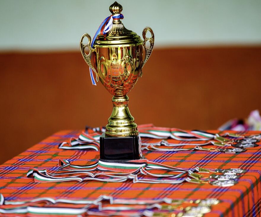 Gold trophy and prize medals arranged on a table